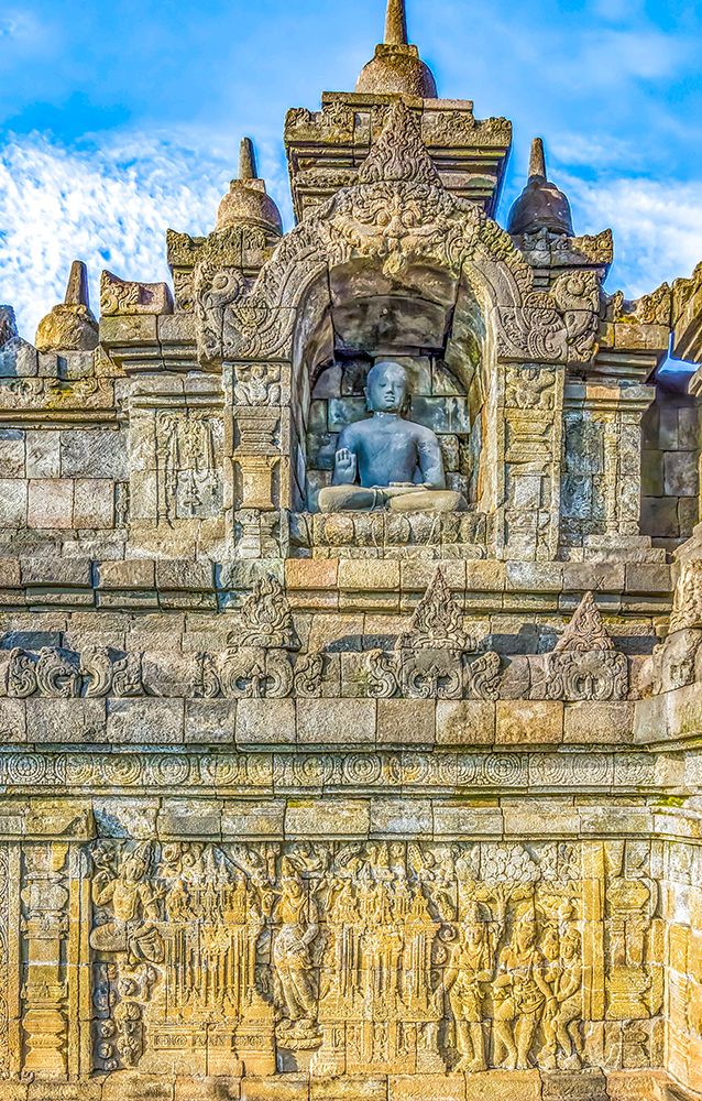 Java, Indonesia. One of the original 504 statues of Buddha in a carved niche of Borobudur Temple.